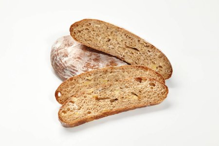 Panes enteros y rebanados de pan de trigo con corteza dorada crujiente y textura aireada mostrada sobre fondo blanco. Concepto de panadería y panadería