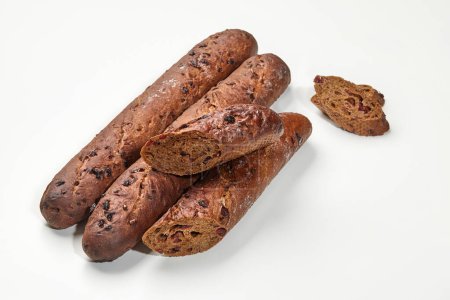 Dunkle Roggen-Baguette-Brote mit herben Preiselbeeren, in Detailaufnahmen auf weißem Hintergrund. Konzept für handwerkliche Backwaren
