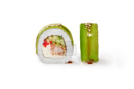 Gros plan de rouleau de sushi appétissant rempli de crevettes tempura, fromage à la crème, concombre et tobiko oeufs enveloppés dans de fines tranches d'avocat, isolé sur fond blanc