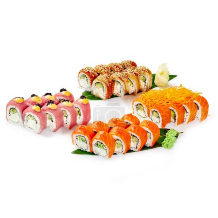 Set for company of Philadelphia rolls with salmon, eel and tuna garnished with masago, sauces and mamenori shavings, presented on bamboo leaves with wasabi and ginger isolated on white background