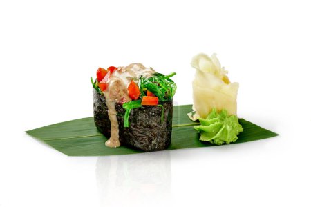 Light gunkan maki sushi with hiyashi wakame, bell pepper, nut sauce and sesame served on bamboo leaf with spicy wasabi and pickled ginger, isolated on white. Japanese style vegetarian snack
