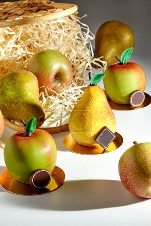 Appetizing natural desserts in shape of pear and apple, decorated with chocolate, with fresh ripe fruits scattered from natural straw basket on light background, evoking summer harvest bounty