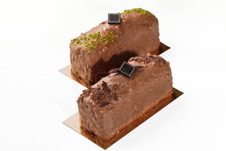 Handwerklich hergestellte süße nussige Schokoladentafeln mit Pistazienkrümeln und Schokoladenchips laden zum Snack ein, isoliert auf weißem Hintergrund