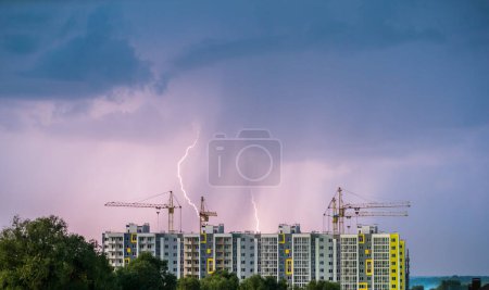 Foto de Lluvia con relámpagos sobre un sitio de construcción donde se están construyendo edificios residenciales. - Imagen libre de derechos