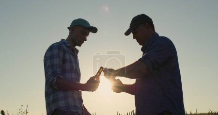 Foto de Dos hombres agricultores abren botellas de cerveza - Imagen libre de derechos