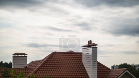 Foto de El techo de la casa está hecho de azulejos rojos, por encima de la casa - Imagen libre de derechos