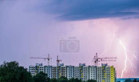 Foto de Construcción de nuevos edificios residenciales. En el fondo, un cielo tormentoso con relámpagos. - Imagen libre de derechos
