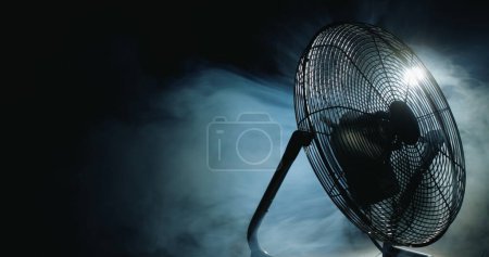 Téléchargez les photos : Les pales des ventilateurs tournent dans les rayons de lumière et de brouillard. Vidéo 4k - en image libre de droit
