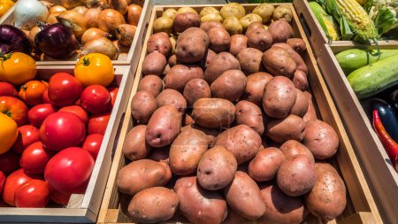 Foto de Patatas en una caja de madera en el mostrador de un mercado de agricultores que venden alimentos locales. - Imagen libre de derechos