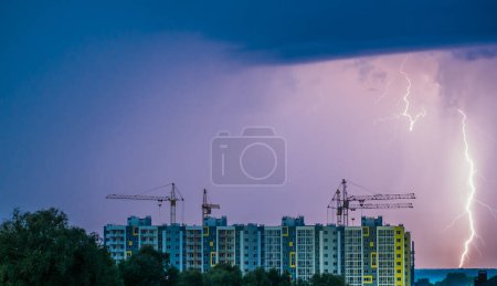 Téléchargez les photos : Site de construction d'un immeuble de plusieurs étages contre le ciel avec foudre. - en image libre de droit