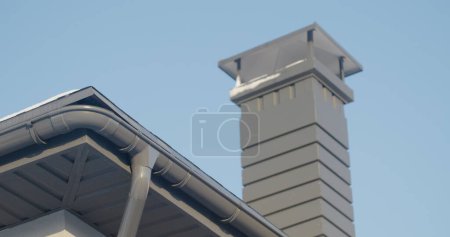 Téléchargez les photos : Le toit de la maison avec un système de drainage et un conduit de ventilation. Par une belle journée d'hiver. - en image libre de droit
