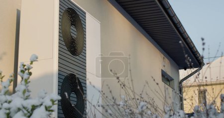 Téléchargez les photos : Thermopompe près d'un chalet moderne. Technologies modernes de chauffage. - en image libre de droit
