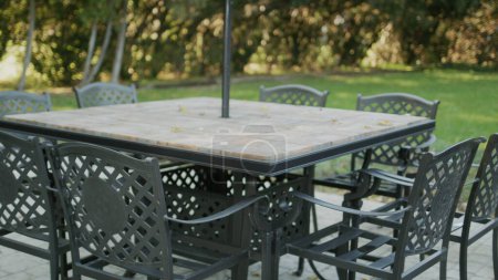 Photo for Empty tables with chairs pulled up - summer terrace of the cafe without visitors. - Royalty Free Image