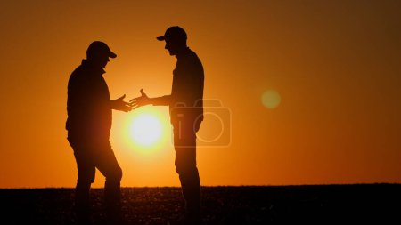 Téléchargez les photos : Une poignée de main ferme entre deux hommes au coucher du soleil. Photo de haute qualité - en image libre de droit