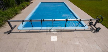 Casa piscina al aire libre cubierta con película para ahorrar productos químicos, agua y calor preservación. Foto de alta calidad