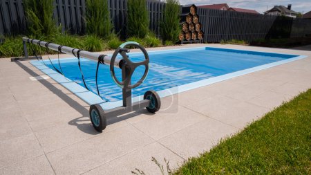 Foto de Casa piscina al aire libre cubierta con película para ahorrar productos químicos, agua y calor preservación. Foto de alta calidad - Imagen libre de derechos