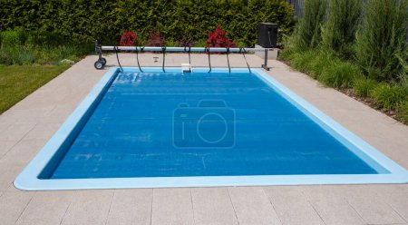 Casa piscina al aire libre cubierta con película para ahorrar productos químicos, agua y calor preservación. Foto de alta calidad