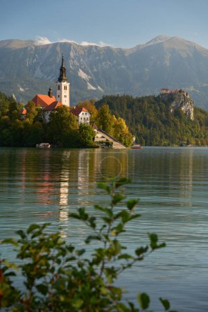 Vertical landscape of Lake Bled on an autumn morning with the famous Church on the Island and the Alps in the background