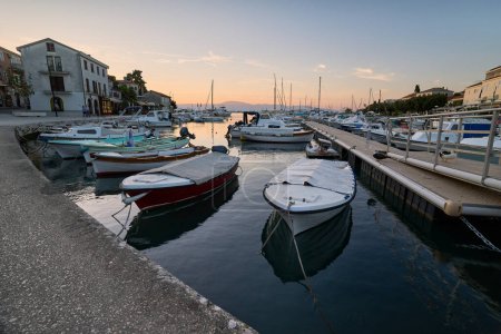 Téléchargez les photos : Marina avec des bateaux amarrés dans la ville croate de Malinska sur l'île de Krk pendant le coucher du soleil - en image libre de droit