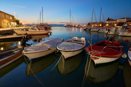 Téléchargez les photos : Marina avec des bateaux amarrés dans la ville croate de Malinska sur l'île de Krk dans la soirée - en image libre de droit