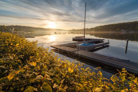 Lake Baldeneysee on the Ruhr River in the city of Essen beautifully illuminated by the rays of the rising sun.