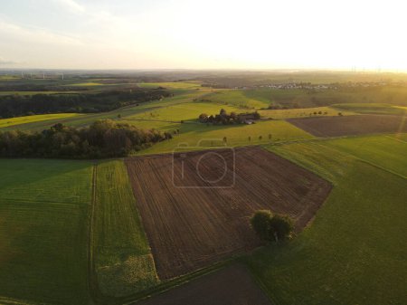 Vue aérienne d'une campagne avec champs agricoles au coucher du soleil