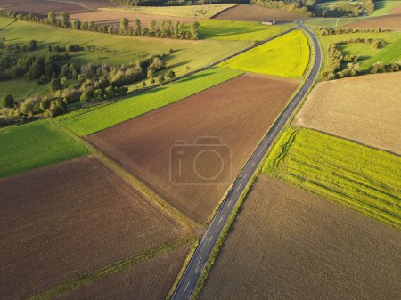 Aerial view of a countryside with farm fields and a asphalt road