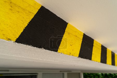 Control de altura negro y amarillo en un garaje subterráneo