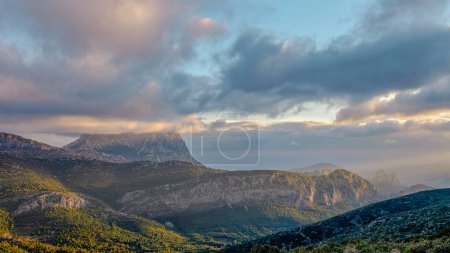 Foto de Montañas y un hermoso cielo con rayos de sol sobre la montaña Puig Campana. Monte Castellet a la derecha. En la Comunidad Valenciana, Alicante, España - Imagen libre de derechos