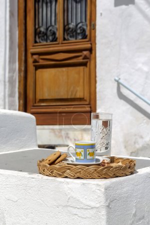 Téléchargez les photos : Tasse avec café aromatique, chaud et savoureux dans une tasse et biscuit sur un plateau gros plan dans le patio donnant sur la porte antique - en image libre de droit