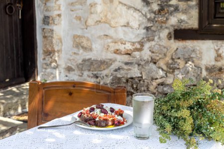 Foto de Cretense Nacional, aperitivo griego (dakos). Galletas con tomates rallados, queso feta, orégano, aceitunas y aceite de oliva en una mesa en el patio de cerca - Imagen libre de derechos