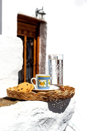 Téléchargez les photos : Tasse avec café aromatique, chaud et savoureux dans une tasse et biscuit sur un plateau gros plan dans le patio donnant sur la porte antique - en image libre de droit