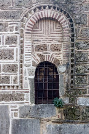 La texture, le motif. Le fond vieux mur beige en pierre naturelle avec une fenêtre
