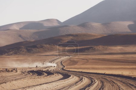 Blurred landscape background. A dirt road near the mountains. The car is driving on a dirt road. Soft focus