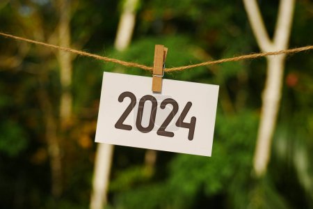 2024 sobre papel colgado en cuerda de yute. Adiós 2023 hola Feliz Año Nuevo 2024 concepto.