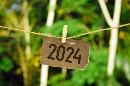 2024 sobre papel colgado en cuerda de yute. Adiós 2023 hola Feliz Año Nuevo 2024 concepto.