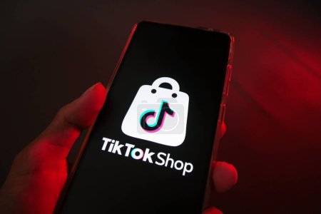 Téléchargez les photos : Main tenant un smartphone avec la boutique TikTok. Marché populaire dans le monde entier. e-commerce commerce sur les réseaux sociaux - en image libre de droit