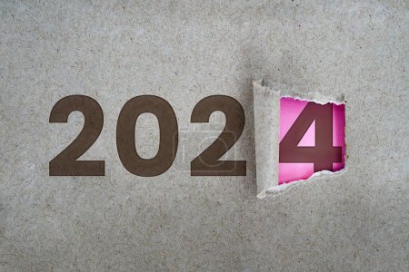 L'année 2024 est derrière le papier déchiré. Nouvel an et nouveau concept d'entreprise.