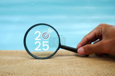 Photo for Magnifying glass and targets 2025. Concept of new year 2025, beginning of success, challenge or career path, change, planning, goals, challenges and new year resolutions. - Royalty Free Image