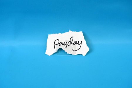 Zerrissenes Papier mit dem Wort Payday isoliert auf blauem Hintergrund