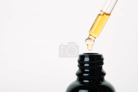 Foto de Cuentagotas con aceite utilizado con fines médicos, primer plano del aceite de CBD sobre fondo gris - Imagen libre de derechos