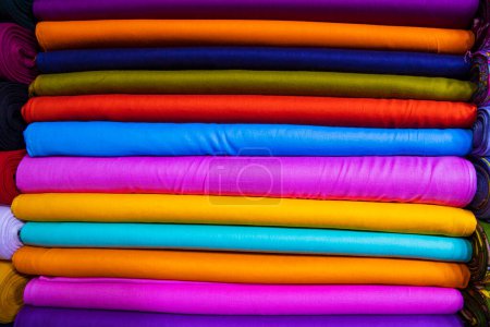 Téléchargez les photos : Artistic variety shade tone colors Textile Fabrics stacked on retail Shop Shelf to sale - en image libre de droit