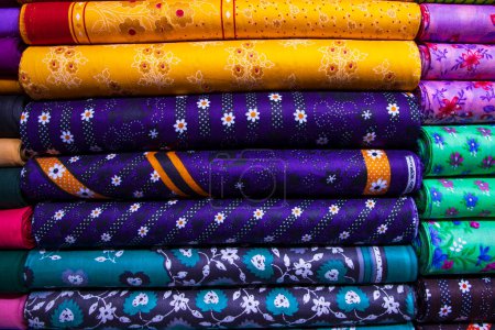 Téléchargez les photos : Variété artistique nuance ton textile couleurs imprimées Tissus empilés sur la vente au détail Boutique Étagère à vendre - en image libre de droit
