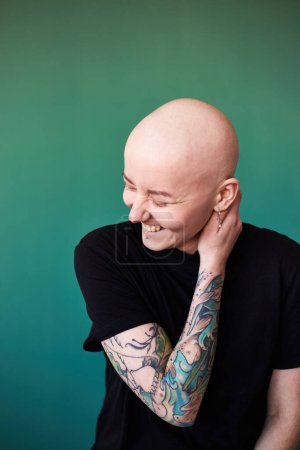 Junge Frau, die an Krebs erkrankt ist, lächelt positiv über zukünftige Genesung. Millennial Weibchen mit rasiertem Kopf