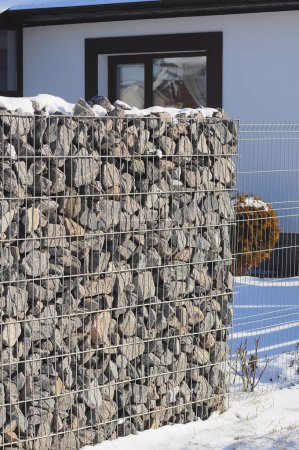 Téléchargez les photos : Un fragment de la clôture de gabion de la maison et du jardin, vue en hiver. - en image libre de droit