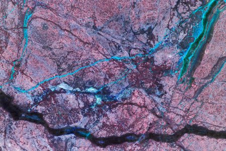 Dieses Nahaufnahme-Foto fängt einen Felsen mit einer markanten blauen Linie ein, die über seine Oberfläche verläuft. Die Struktur der Felsen wird durch die Kontrastfarbe der Linie hervorgehoben.