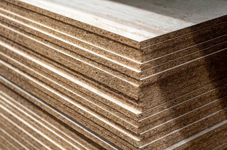 Photo for Construction and furniture materials in the form of wood chip boards stacked at a storage facility - Royalty Free Image
