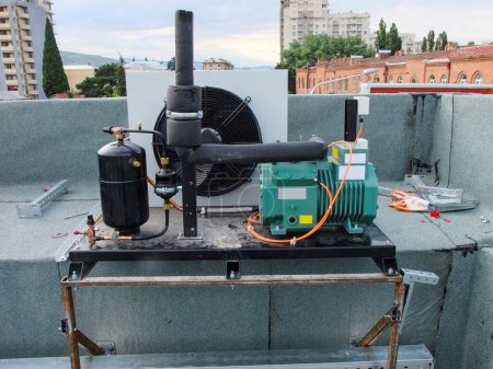 Installation d'équipement CVC sur le toit d'un restaurant, avec compresseur et climatiseur.