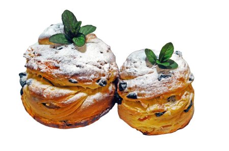 Sweet pastries for Easter, raisin Craffins garnished with powdered sugar and mint, isolated.
