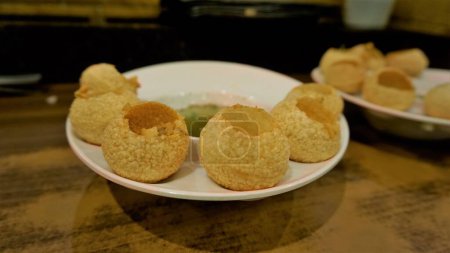 Téléchargez les photos : Pani Puri or Golgappa or Puchkas from a white plate which is popular Indian Chat menu. - en image libre de droit